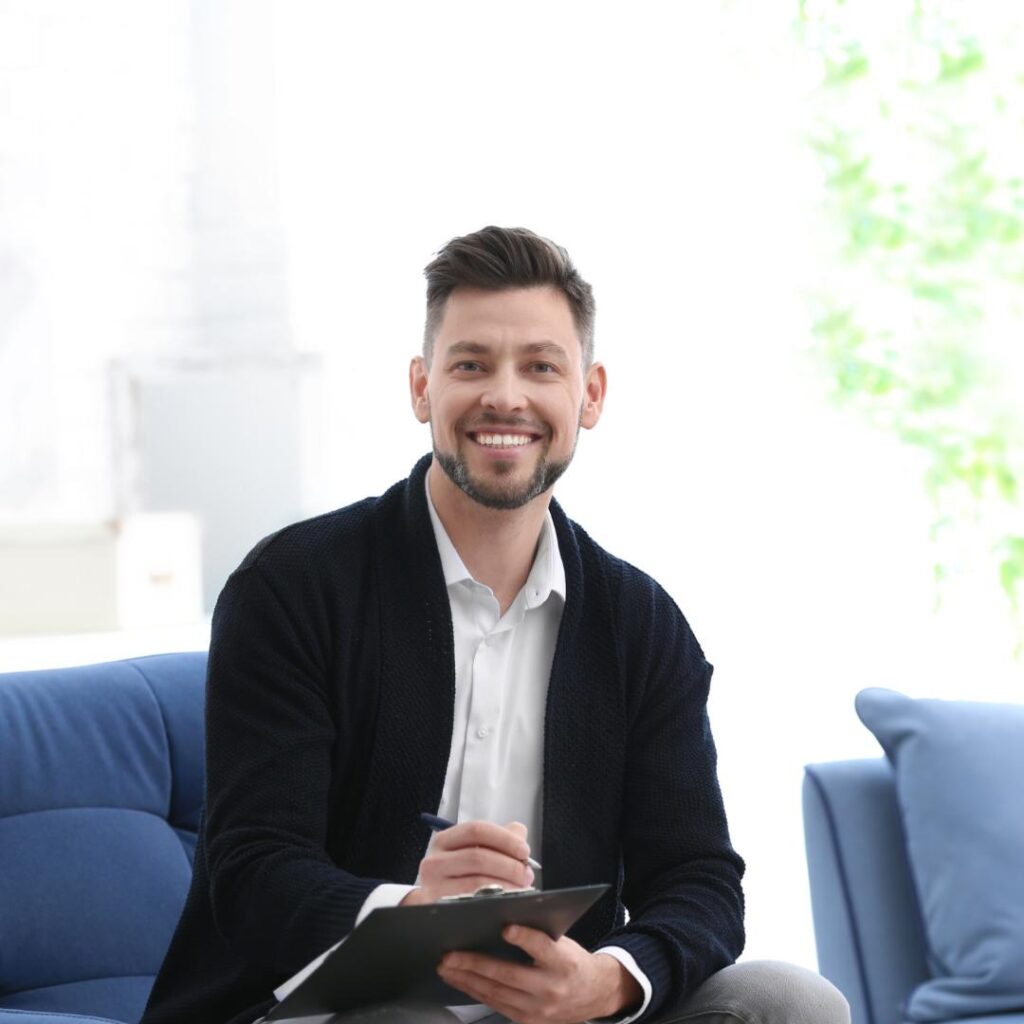 A professional speaker seated on a sofa, signing contract