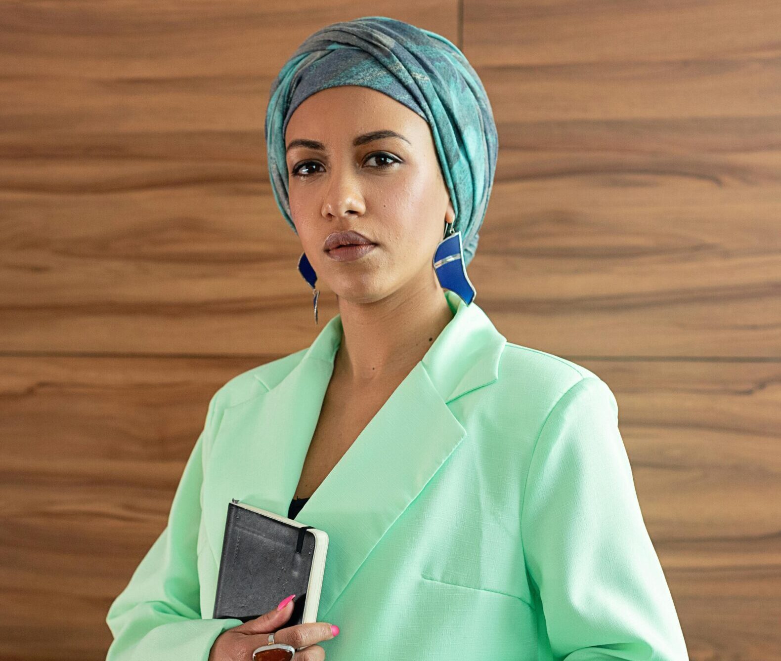 Corporate shot of a woman in green suit with green scarf